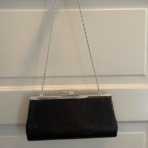 Black sequined evening clutch with bow detail.